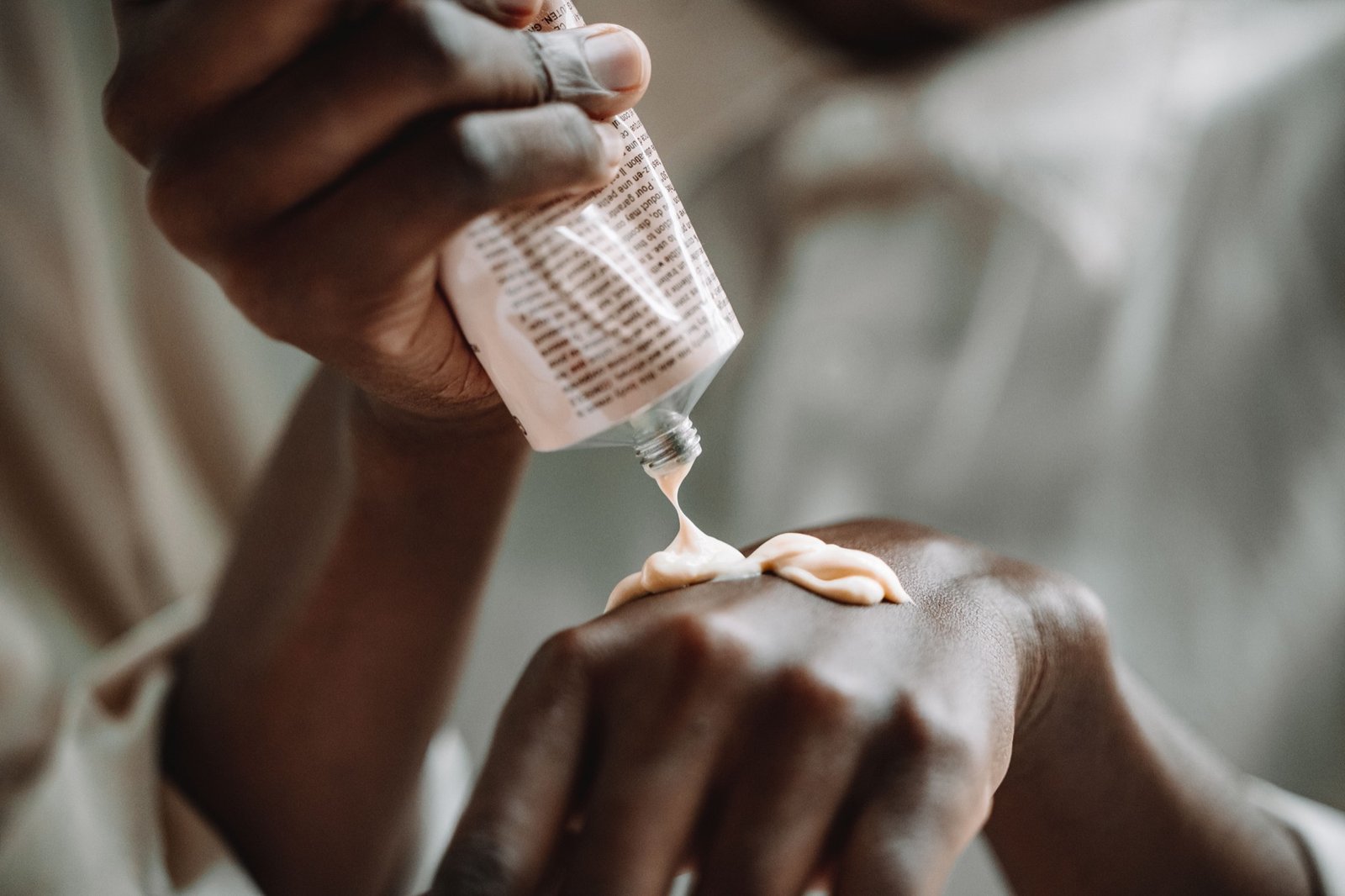 Applying a thin film of medicated cream from a tube