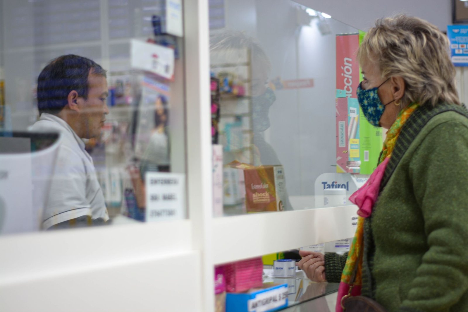 Customer speaking with a pharmacist at the pharmacy counter