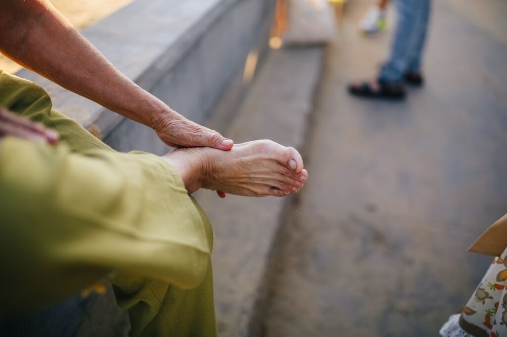 Elderly person massaging their foot for relief from nerve-related discomfort