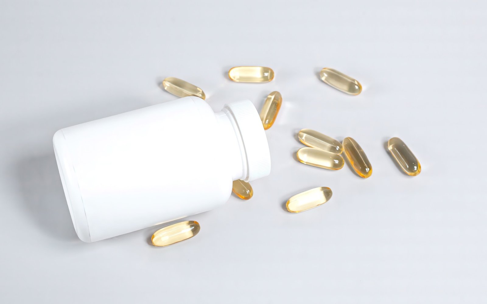 Fish oil softgel capsules spilled from a bottle