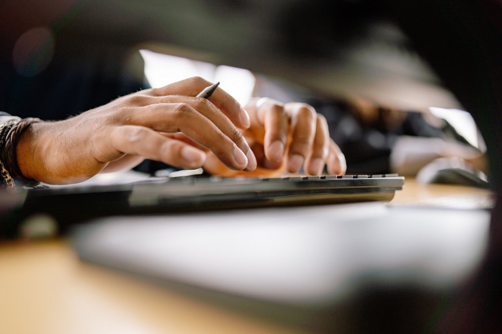 Person typing on a keyboard, a common repetitive strain on the wrist
