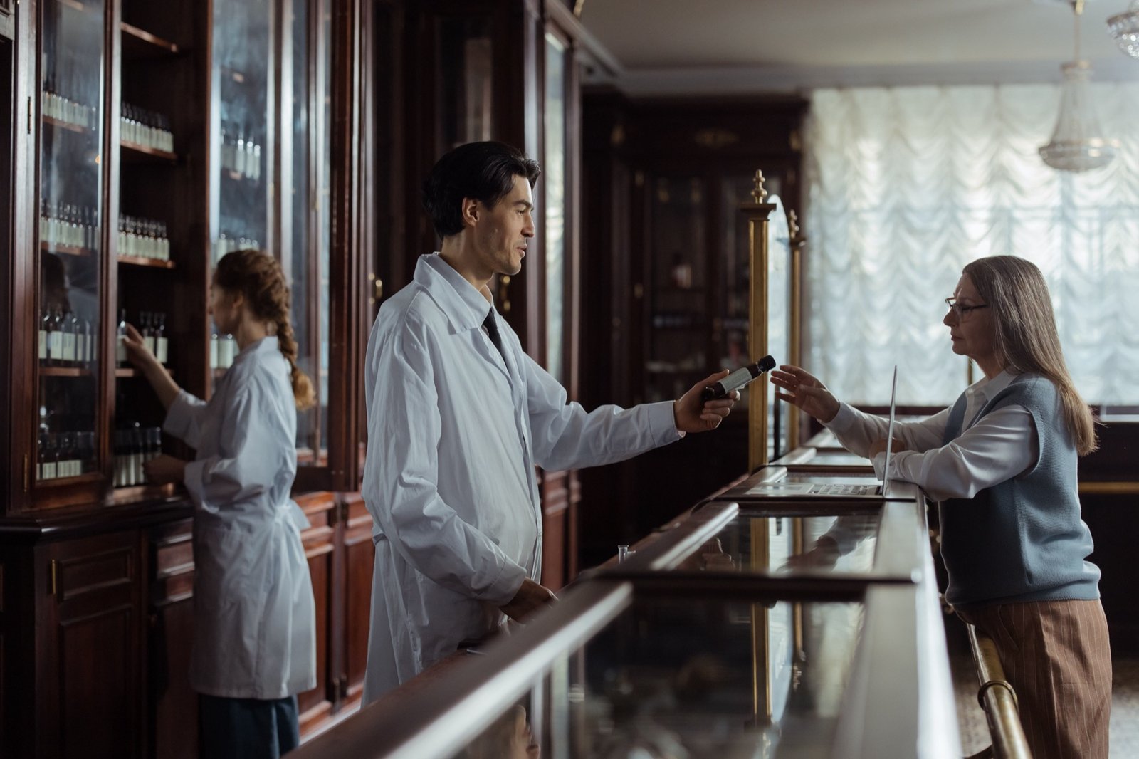 Pharmacist handing medication to a customer at the pharmacy counter