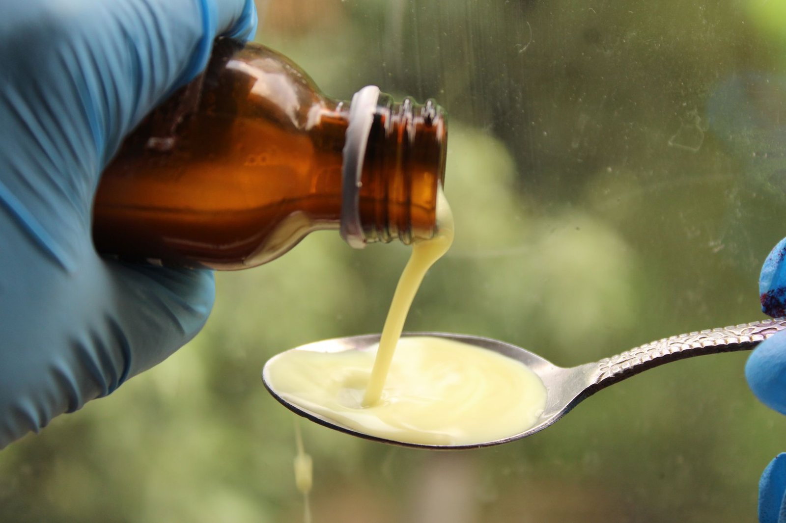 Liquid medicine being poured into a dosing spoon