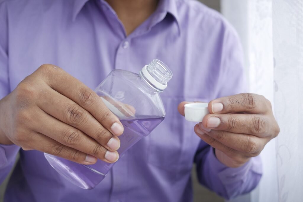 Pouring mouthwash into the cap before rinsing