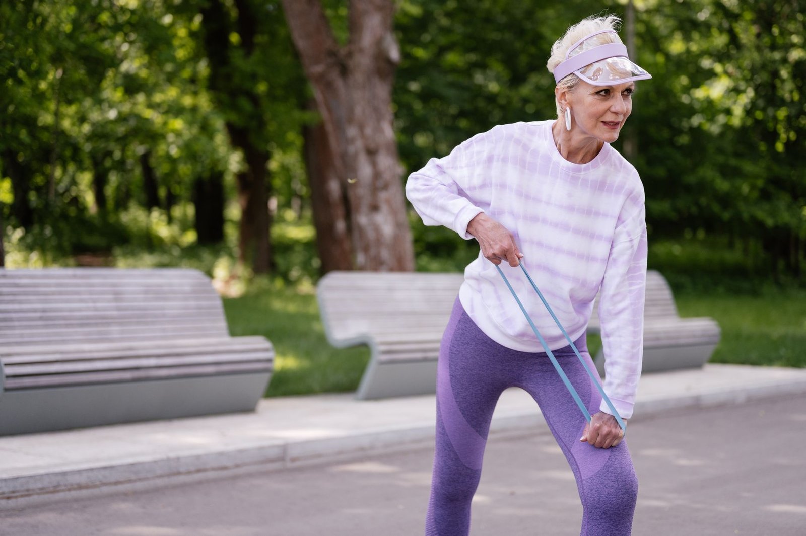 Senior woman exercising outdoors with a resistance band