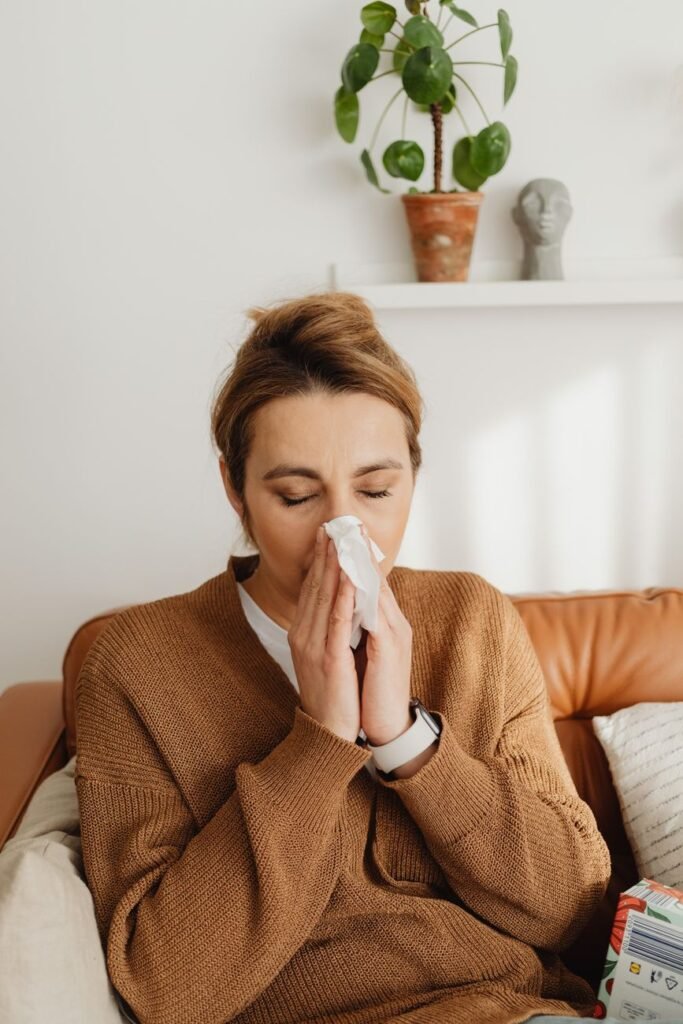 Woman blowing her nose from allergy or sinus congestion symptoms