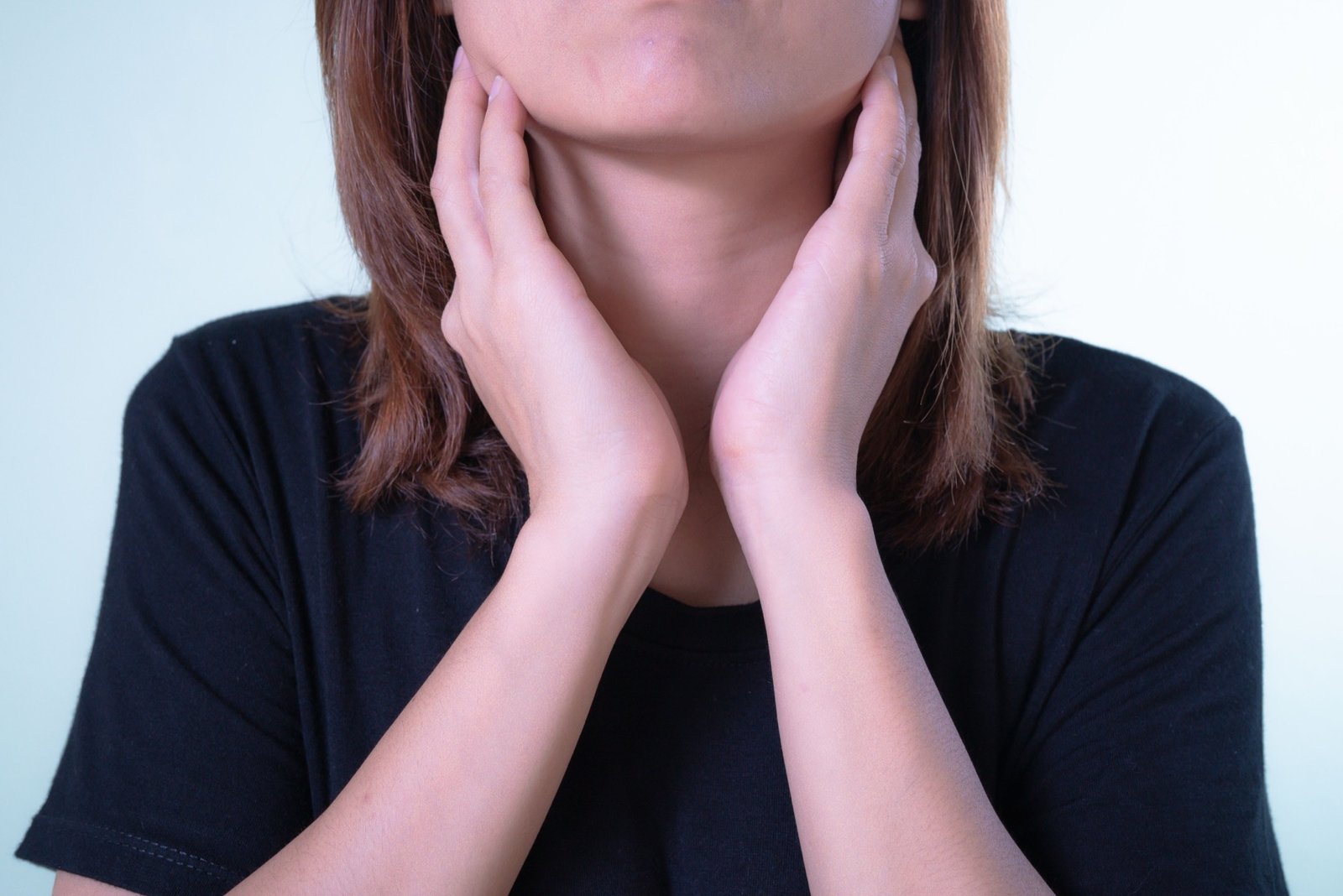 Woman touching her neck due to sore throat discomfort
