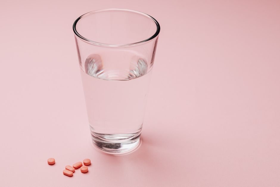 Glass of water with laxative tablets