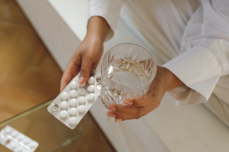 Glass of water with medication tablets