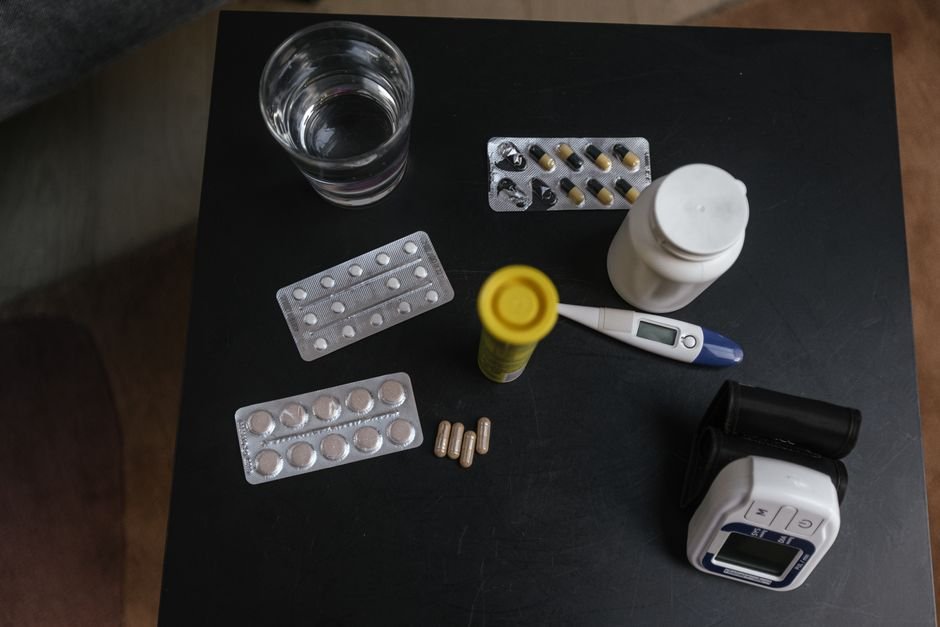 Medicine tablets and water glass on table