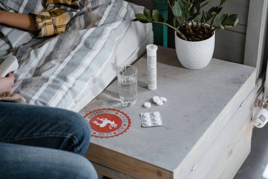Glass of water with pills on nightstand