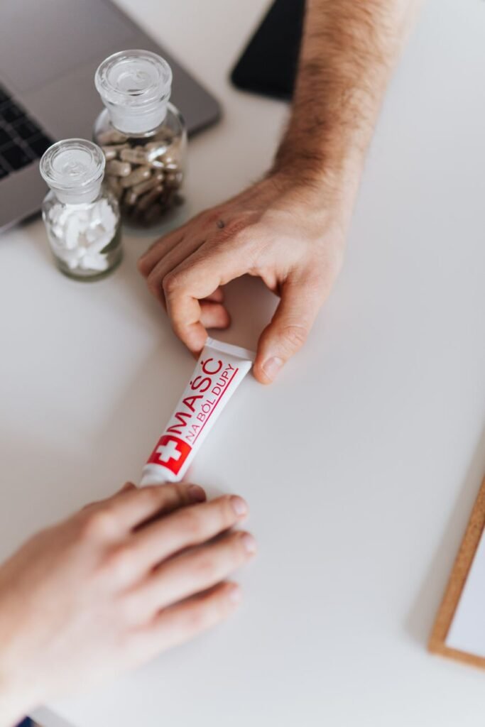 A pharmacist handing a tube of hemorrhoid cream to a patient, the kind of guidance available at South Fork Pharmacy