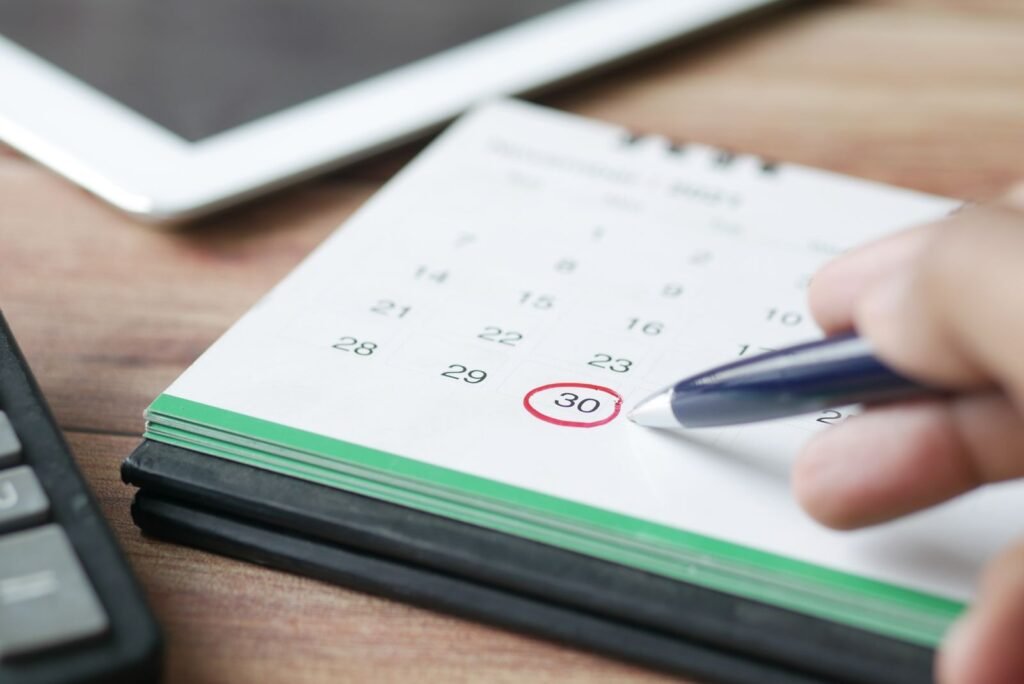 Hand circling a date on a calendar to track how long you can safely use hemorrhoid cream