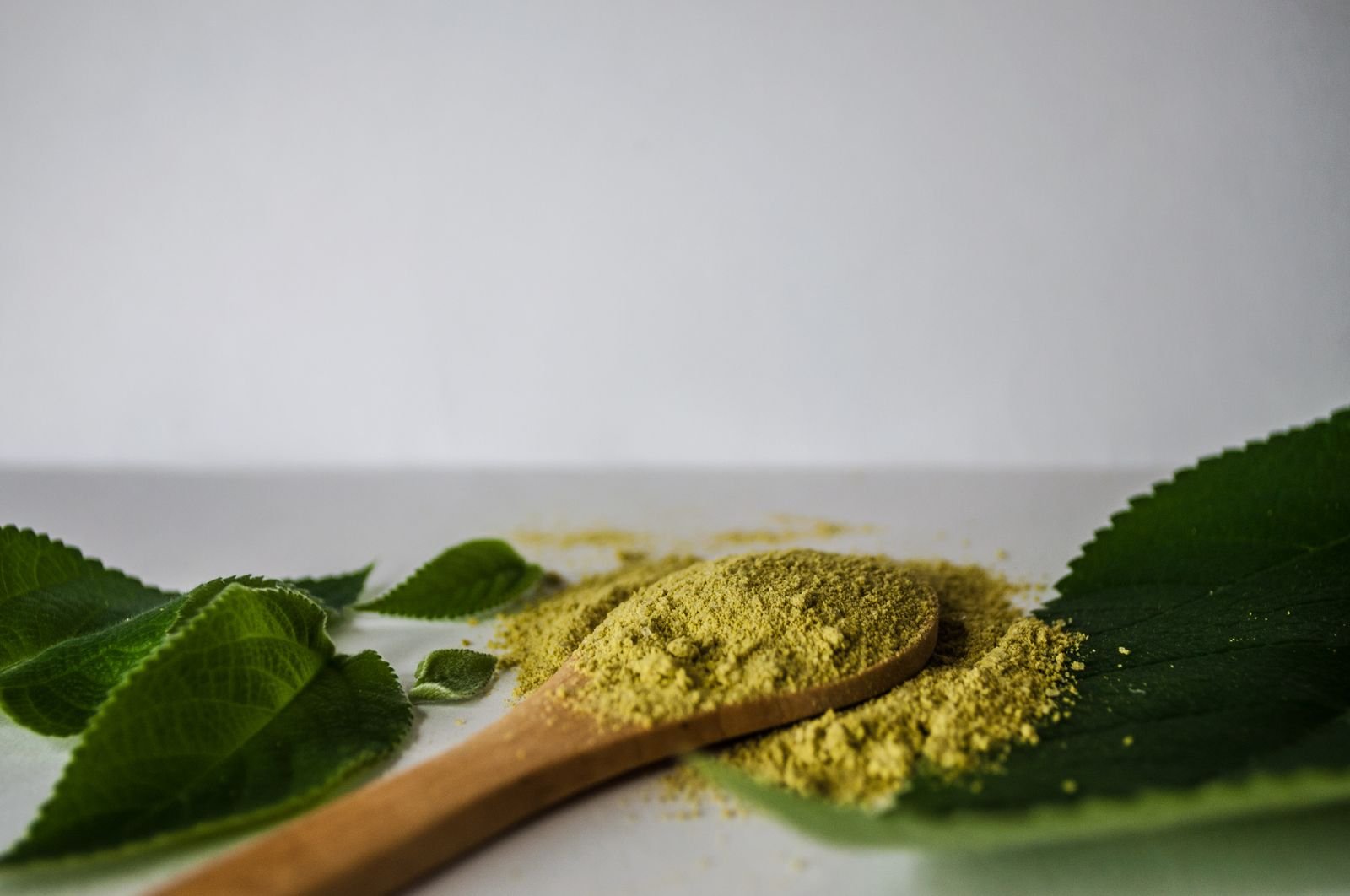 Fine powder on a wooden spoon representing a powdered fiber supplement like Konsyl daily psyllium fiber