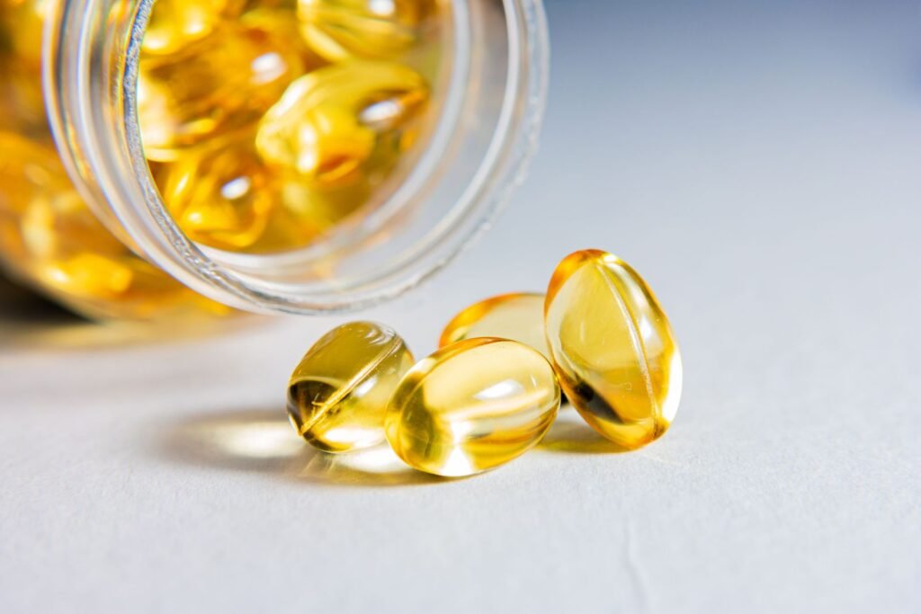 Amber softgel capsules spilling from a clear jar, like the softgels sold as a Colace generic docusate sodium