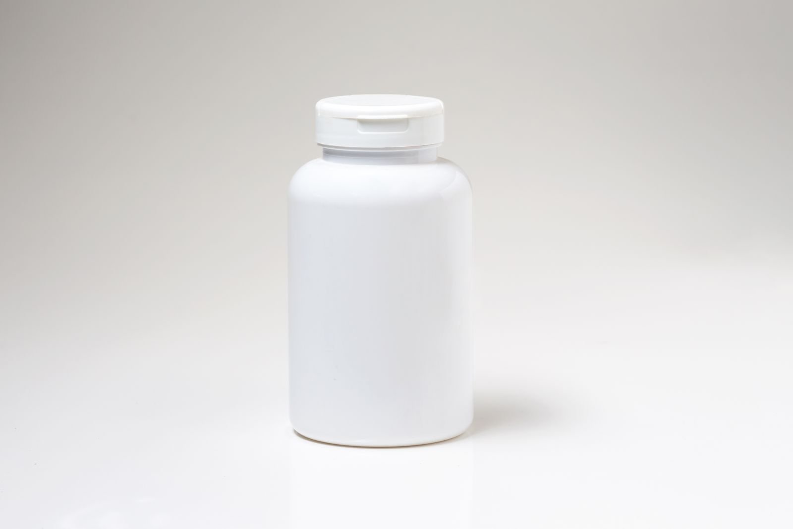 Plain white pill bottle standing on a light background, representing the Tylenol for hemorrhoids question