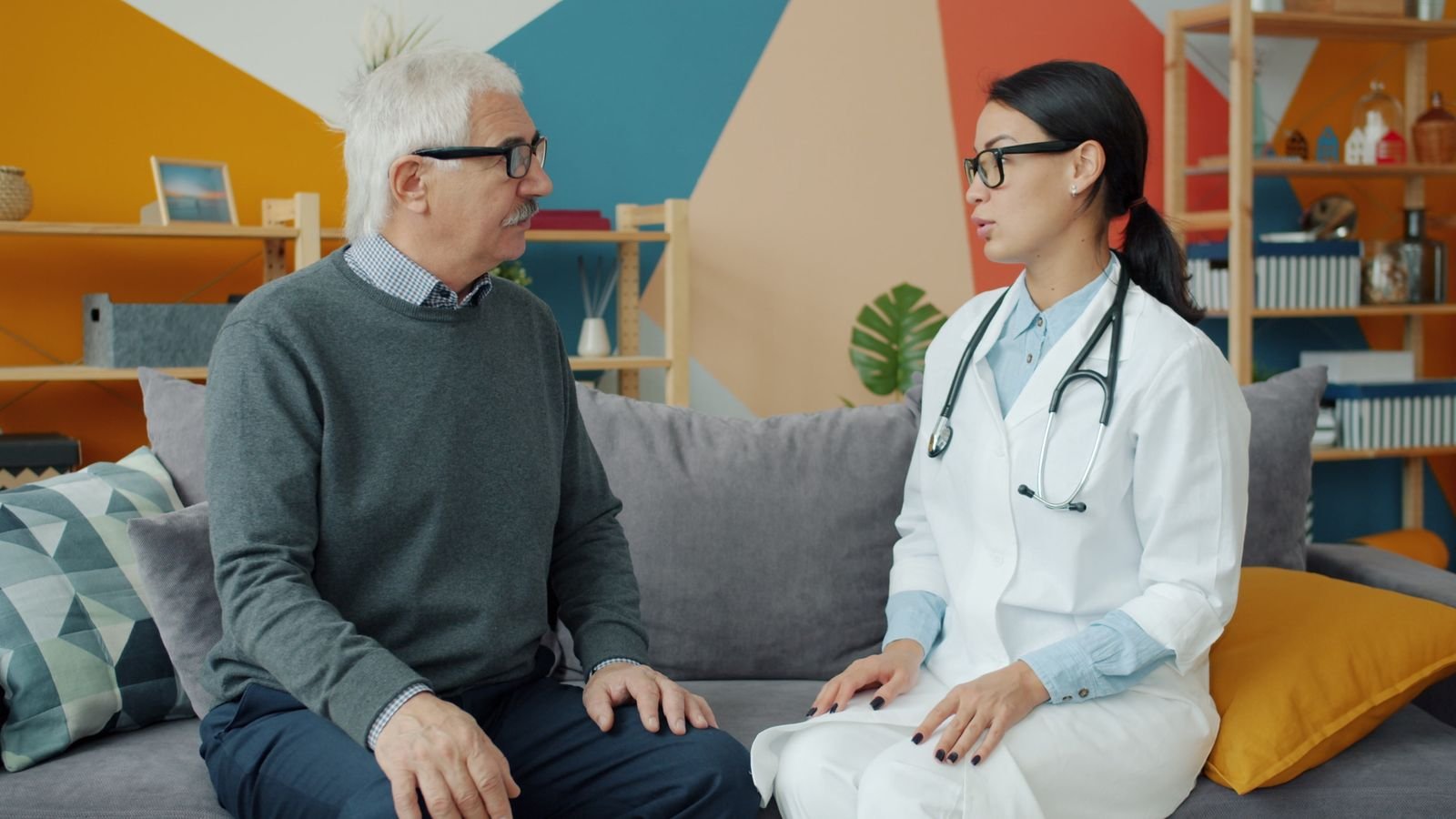 Healthcare professional talking with an older man about his medicines before he starts hydrocortisone acetate suppositories