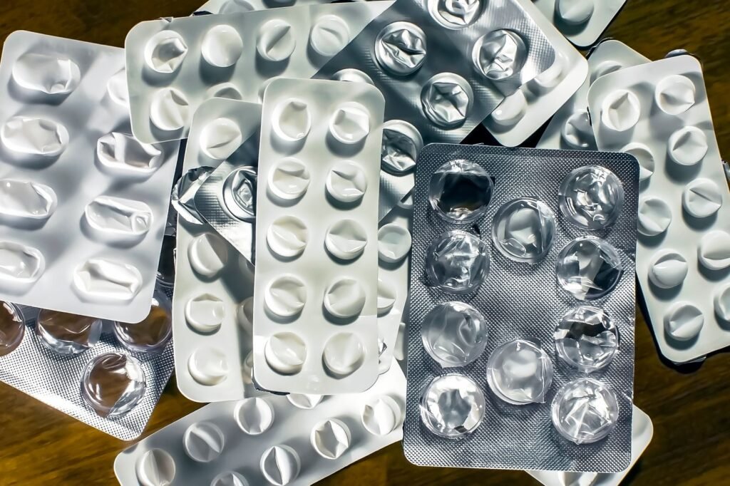 Medication blister packs on a wooden table illustrating how to compare the best hemorrhoid suppositories