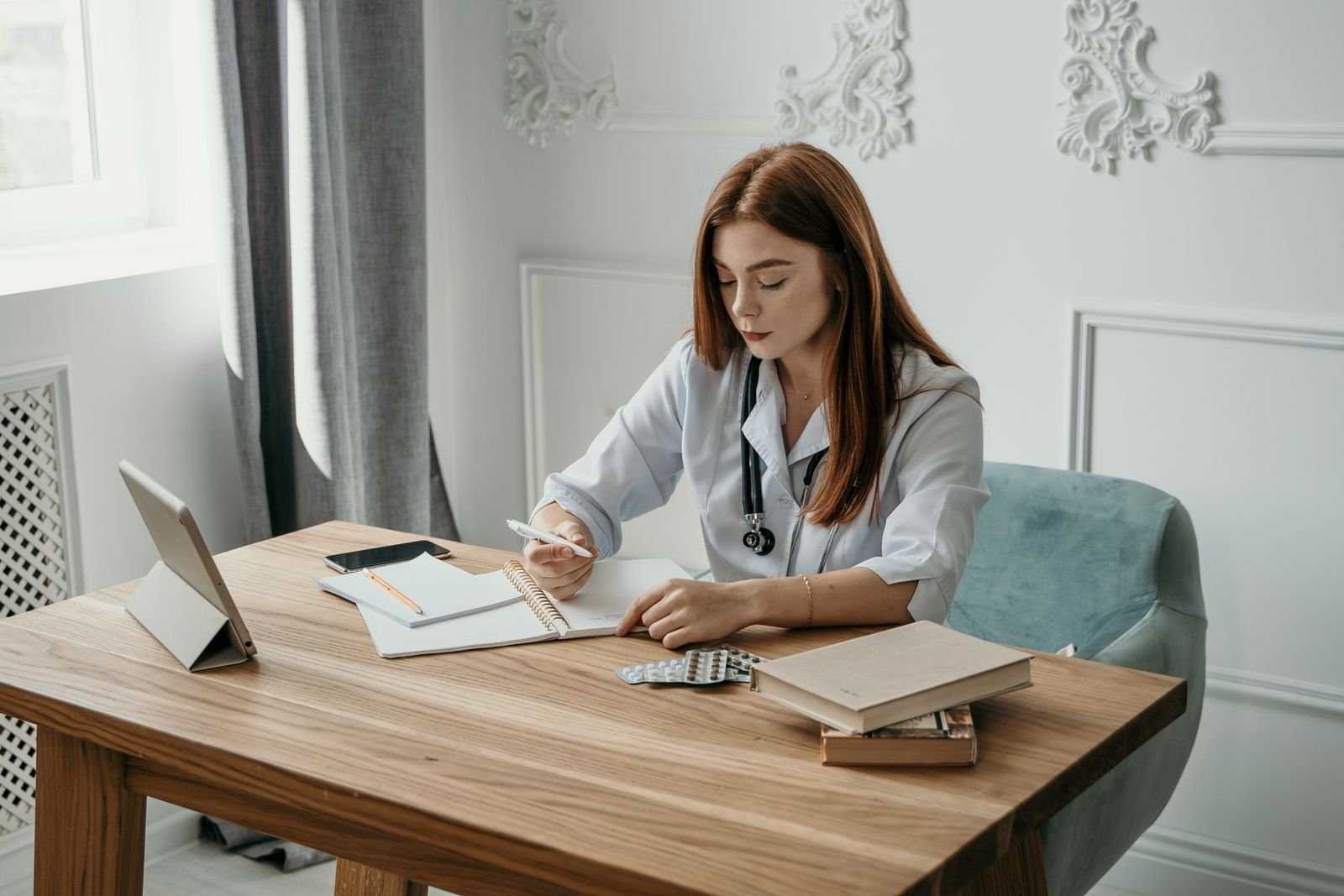 Clinician taking notes at a desk beside a blister pack, ready to help match a Preparation H product to a symptom