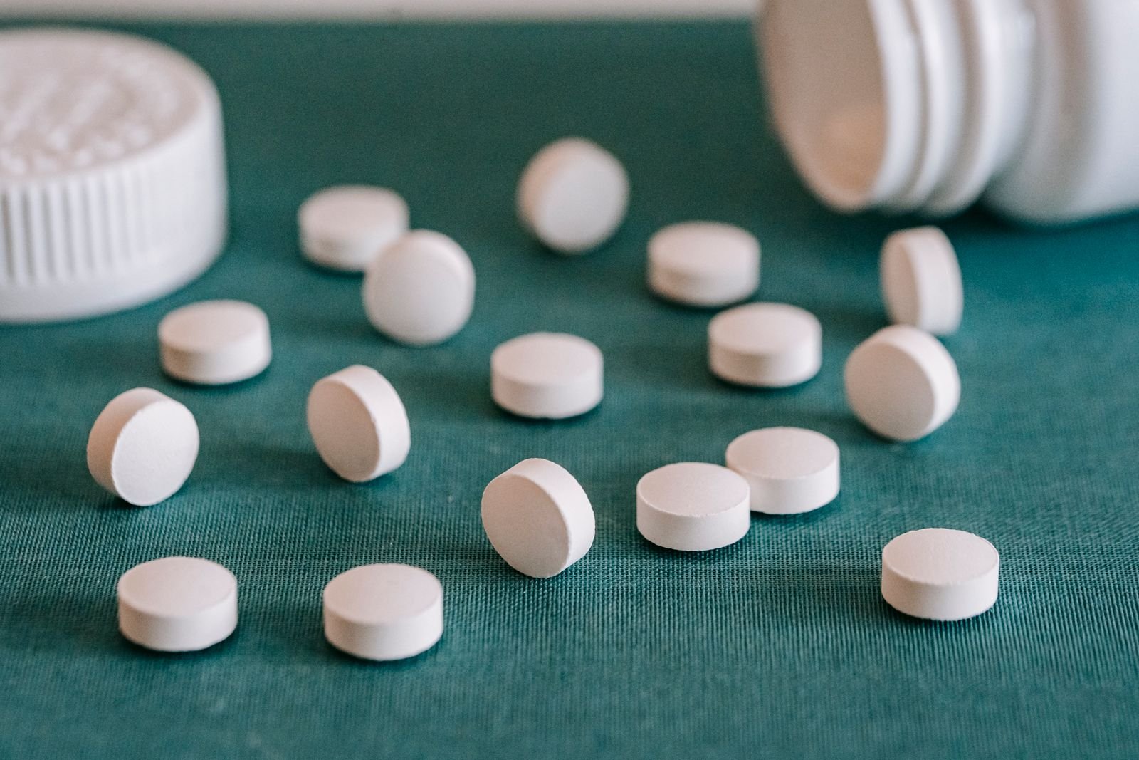 White tablets spilling from a plain white bottle, like the combination tablets that contain docusate and senna