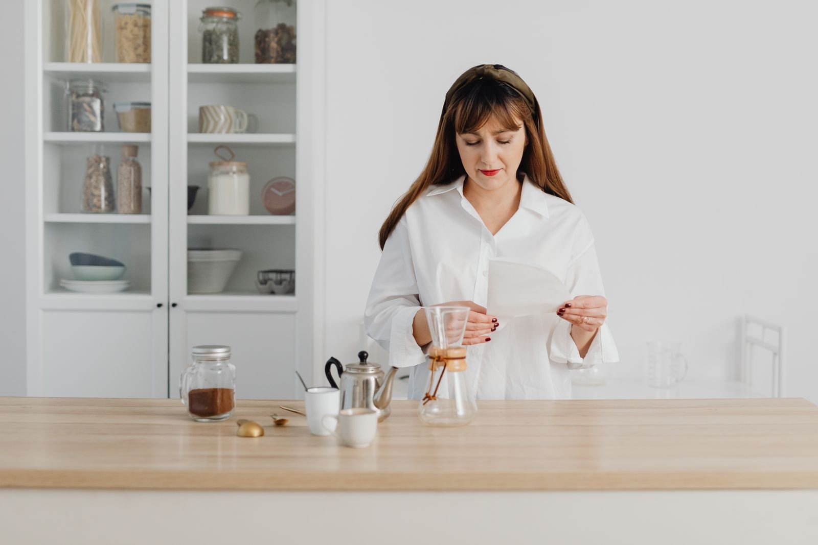 Woman reading instructions carefully in a bright kitchen, like reading the directions on Preparation H before use