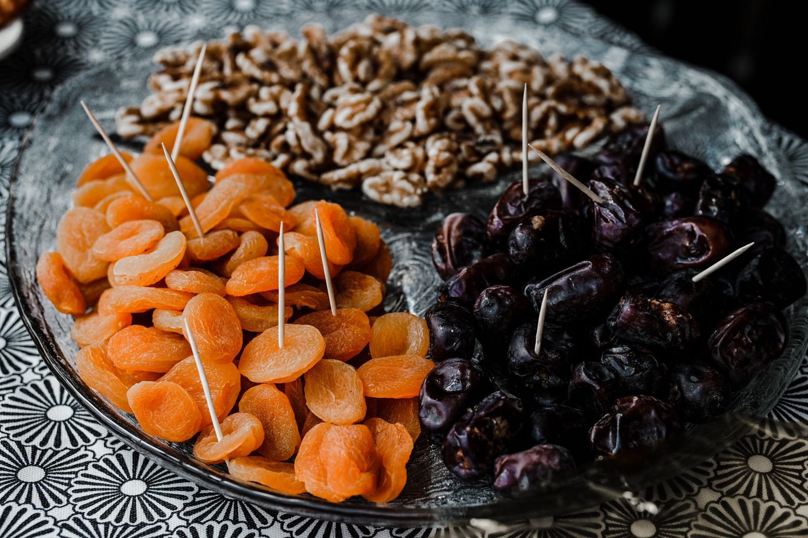 Dried apricots, prunes and walnuts on a plate, fiber-rich foods that support regular bowel movements