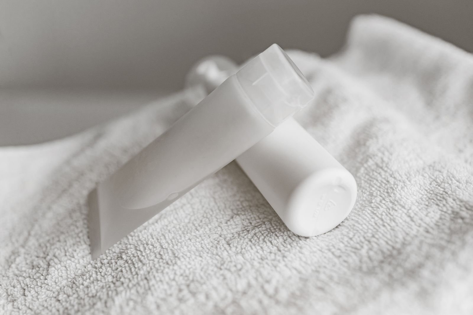 White cream tubes resting on a towel, representing the strongest numbing cream for hemorrhoids