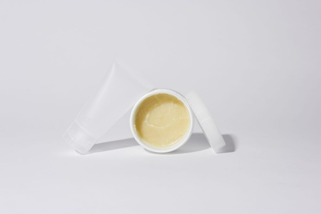A cream tube and an open ointment jar side by side comparing cream vs ointment vs suppository forms