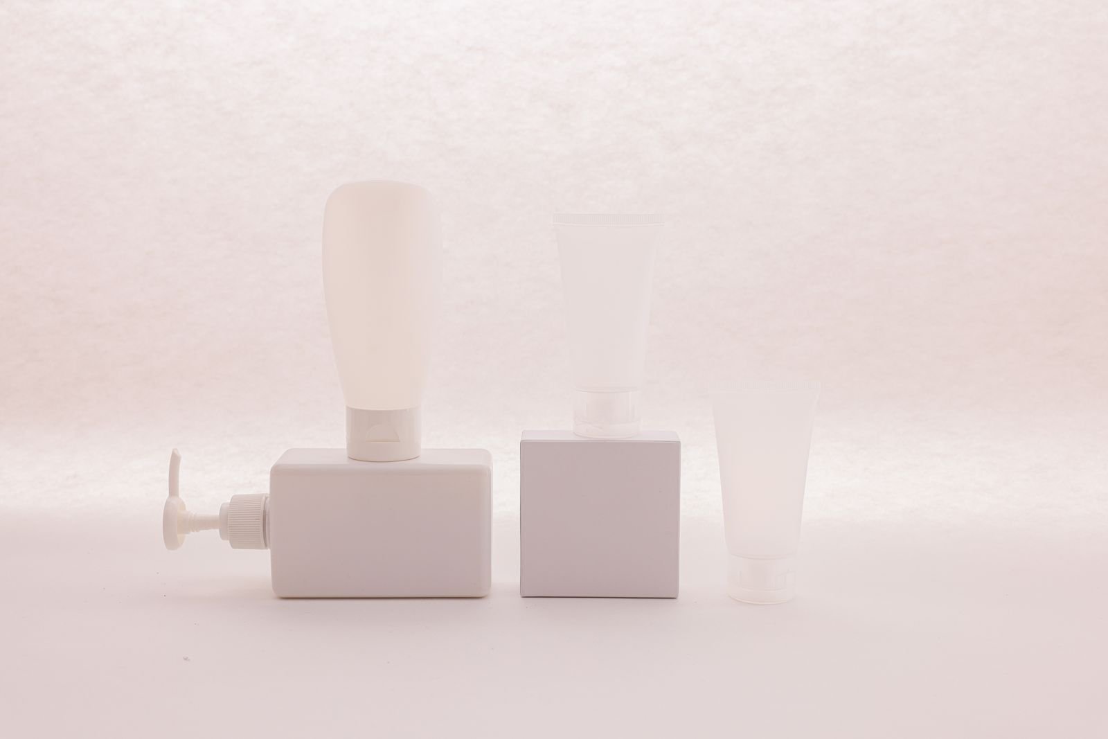 White cosmetic tubes and bottles side by side, representing the choice between Preparation H cream or ointment