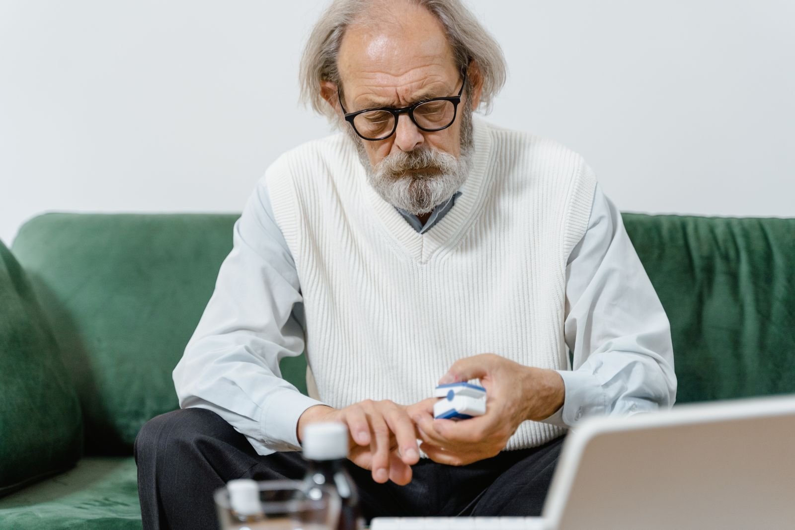 Older man in glasses examining a medication package carefully before taking Tylenol for hemorrhoids
