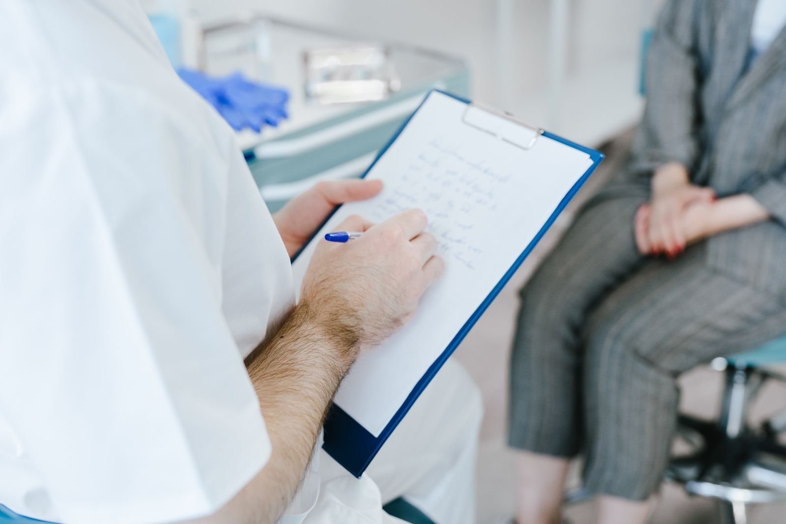 Healthcare professional writing notes on a clipboard during a consultation about choosing between stimulant vs osmotic laxatives