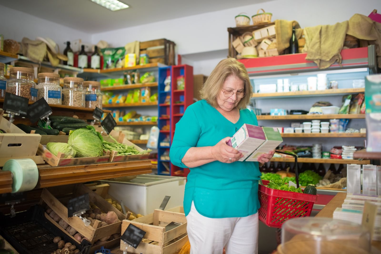 Older woman reading a product label in a store aisle, deciding whether Preparation H with hydrocortisone fits her symptoms