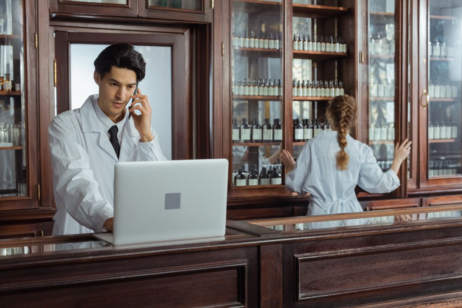 Pharmacist at a counter with a laptop, ready to explain the difference between Senexon and Senexon-S
