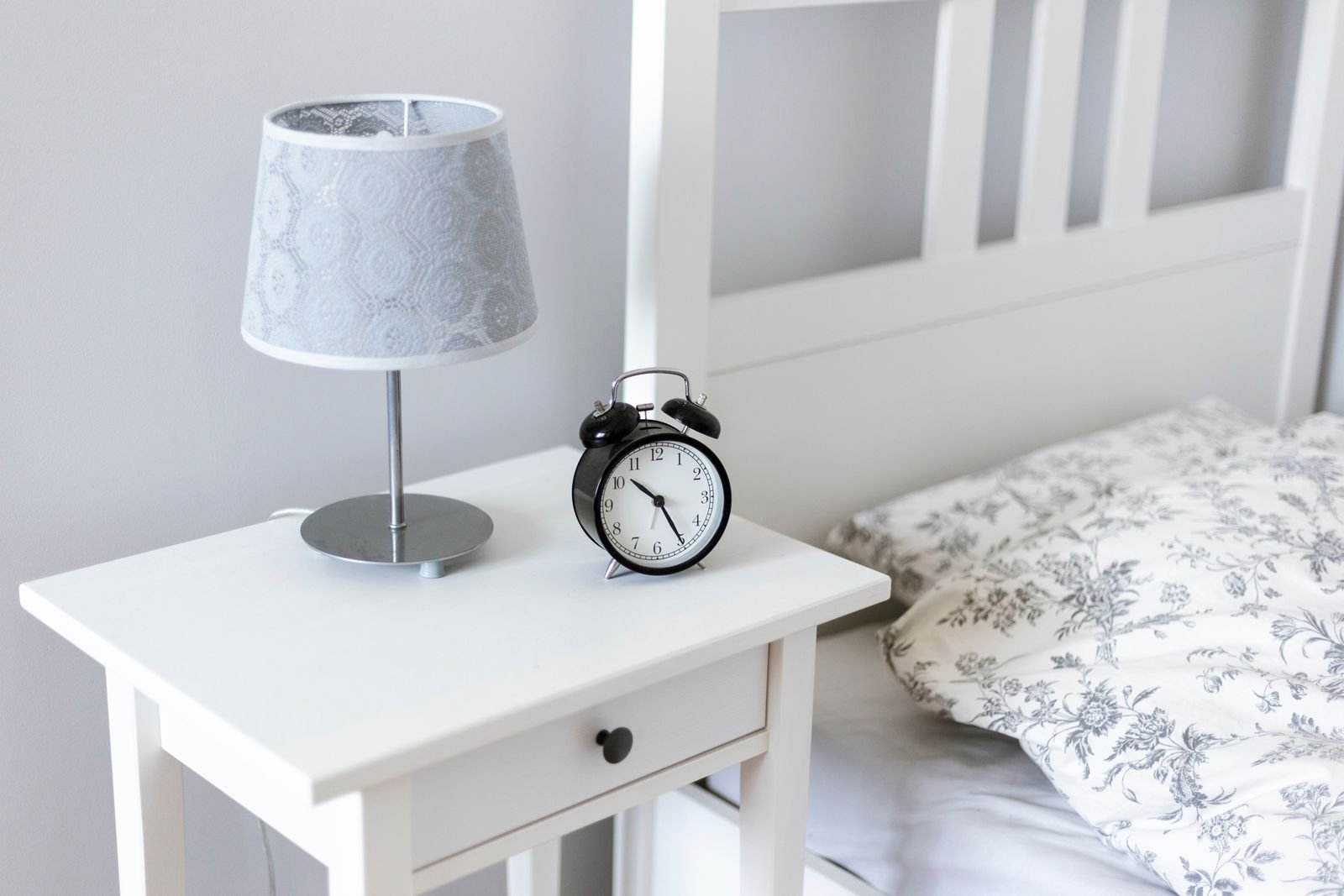 Bedside table with a lamp and alarm clock, since bedtime is a popular time to use Preparation H suppositories