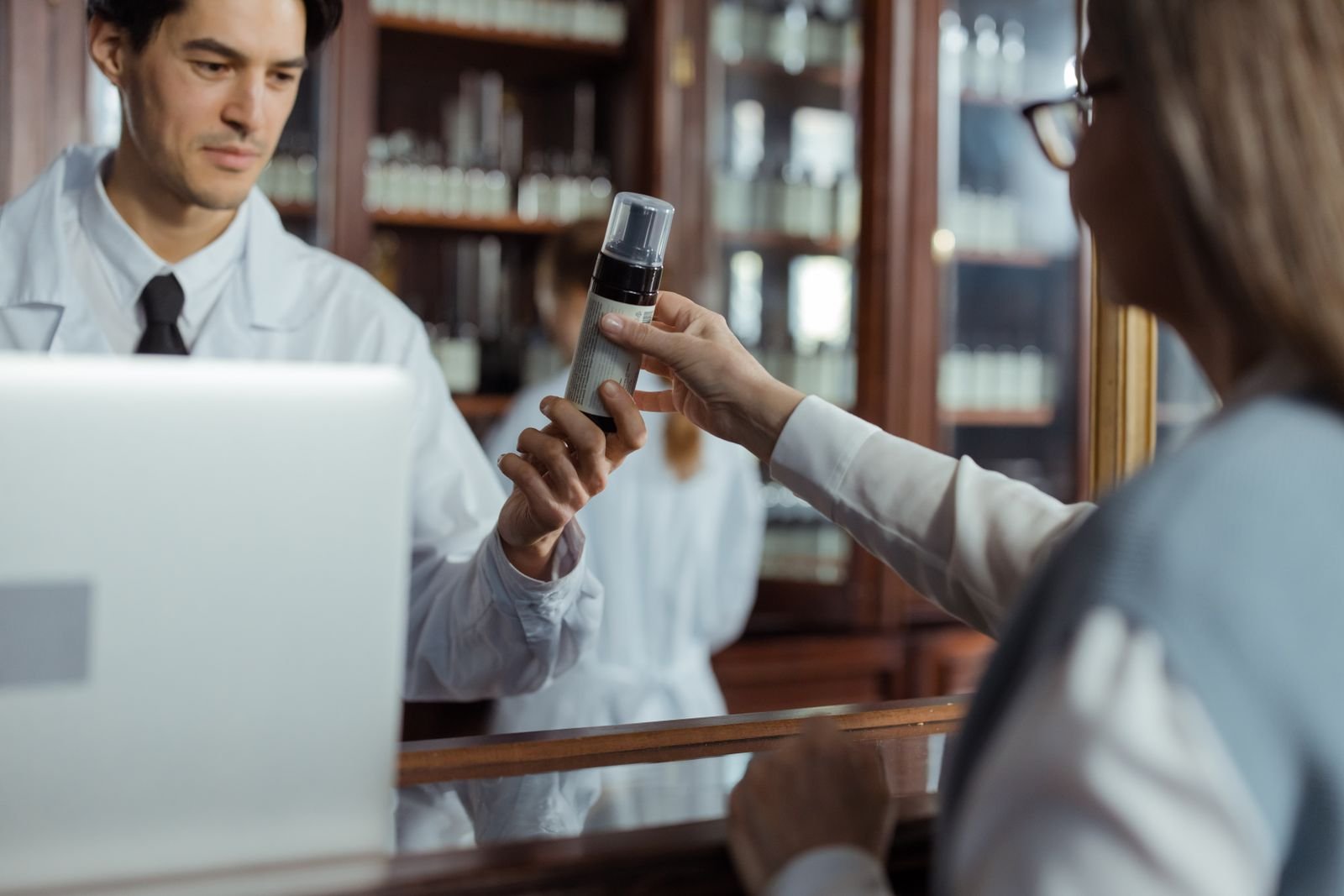 Pharmacist handing a product across the counter, comfort care while arranging treatment for grade 4 hemorrhoids